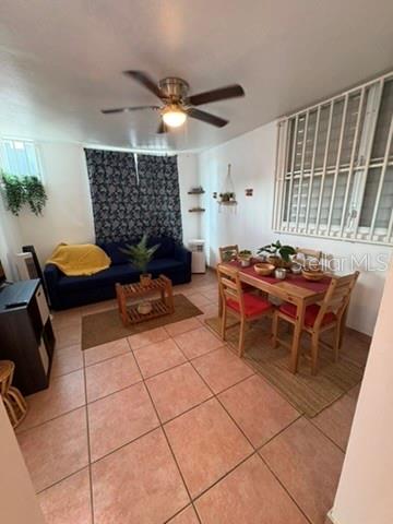 A living and dining area with tile floors, a blue sofa, and a wooden table — 14 JOSE JULIAN ACOSTA Apt E1, VEGA BAJA, PR