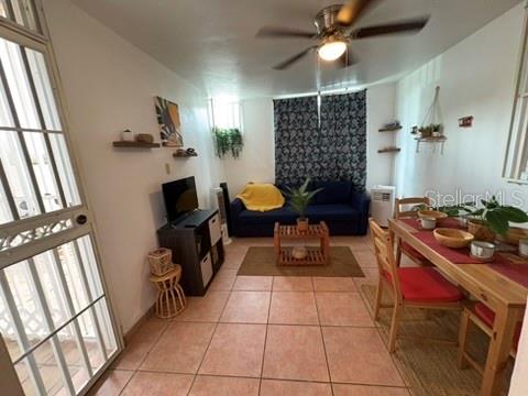 A living and dining area features tile floors, a blue sofa, and a wooden table — 14 JOSE JULIAN ACOSTA Apt E1, VEGA BAJA, PR