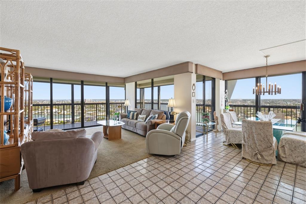 A living and dining area with tile floors, floor-to-ceiling windows, and a panoramic water view — 9495 BLIND PASS ROAD UNIT 1208, ST PETE BEACH, FL