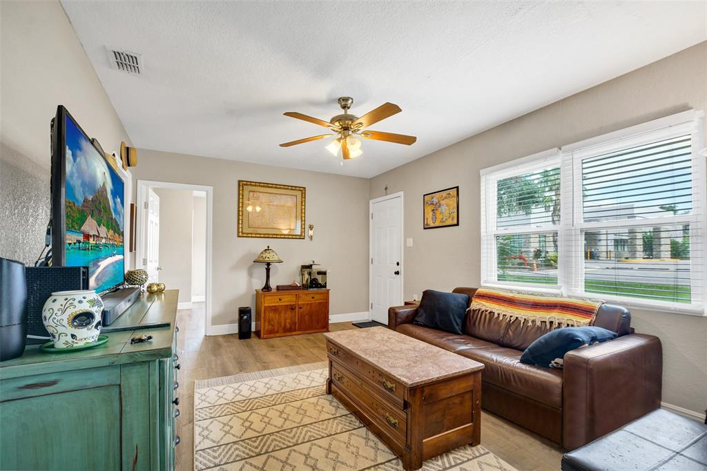 A living room features a brown leather sofa, a wooden coffee table, and a television — 104 AVENUE K NE, WINTER HAVEN, FL