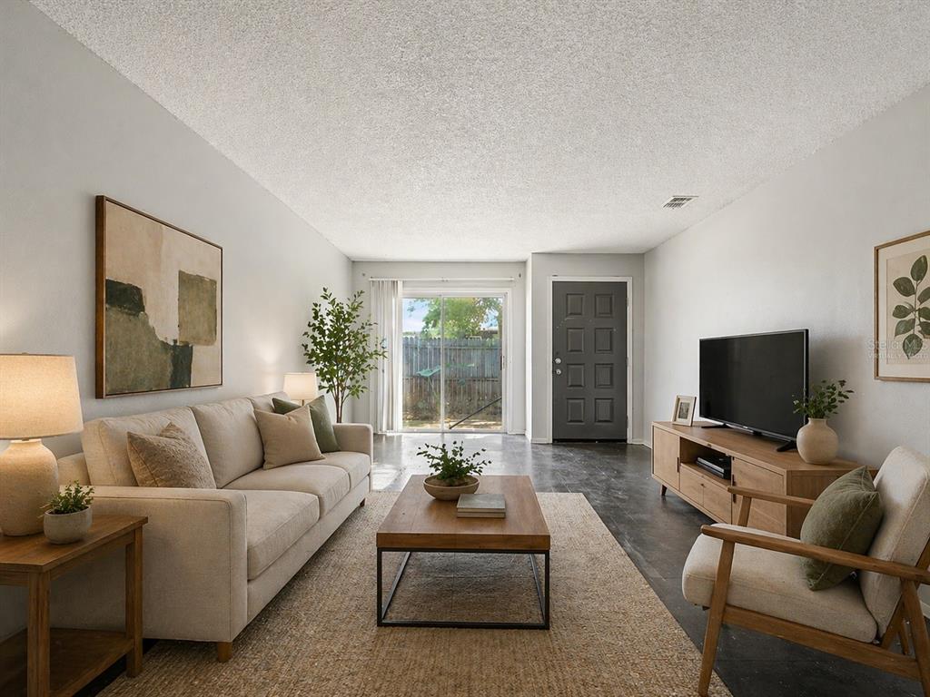 A living room features a beige sofa, wooden coffee table, television, and sliding glass doors — 2950 SE 53RD COURT, OCALA, FL