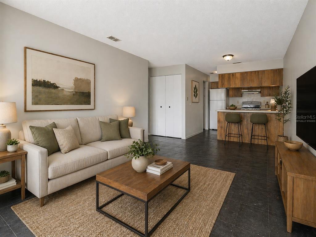 A living room with a sofa, coffee table, and an open kitchen with wood cabinets — 2950 SE 53RD COURT, OCALA, FL