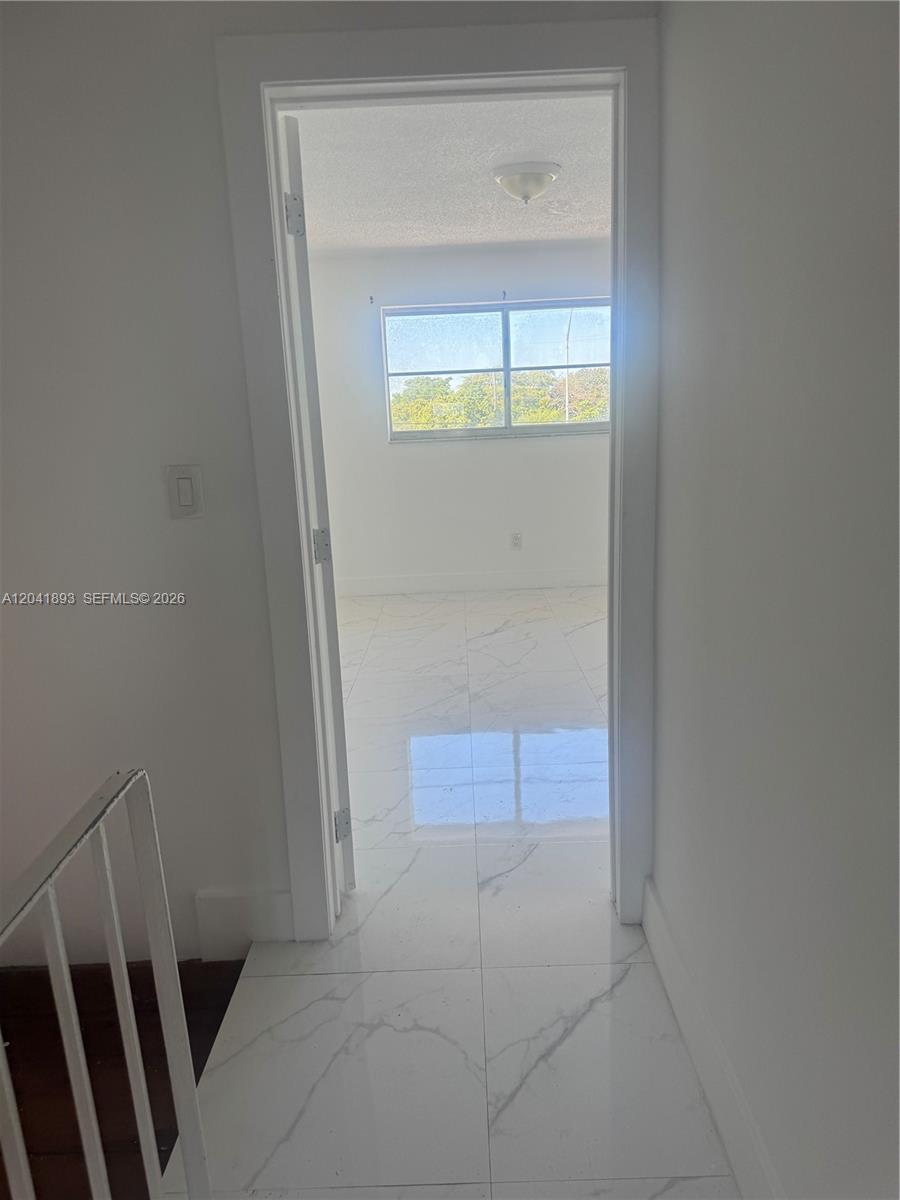 A view through a doorway shows a room with white marble-patterned tile flooring — 1551 W Okeechobee Rd # 19, Hialeah FL 33010, HIALEAH, FL