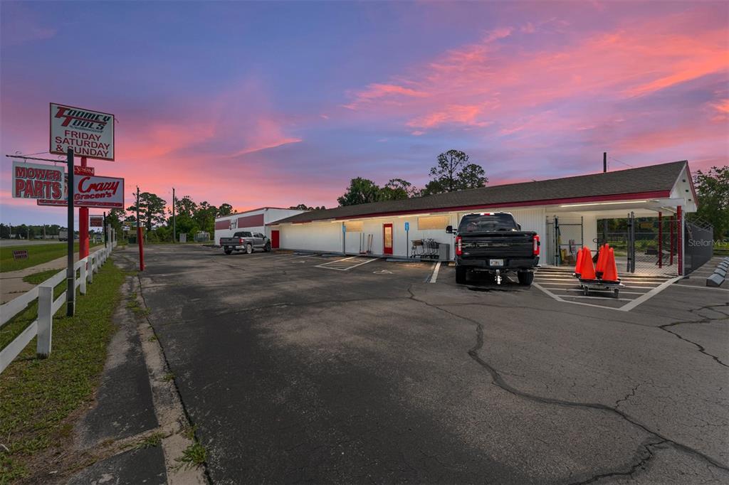 A commercial building with a parking lot and signage under a colorful sunset sky — 17313 NE US HWY 301, WALDO, FL