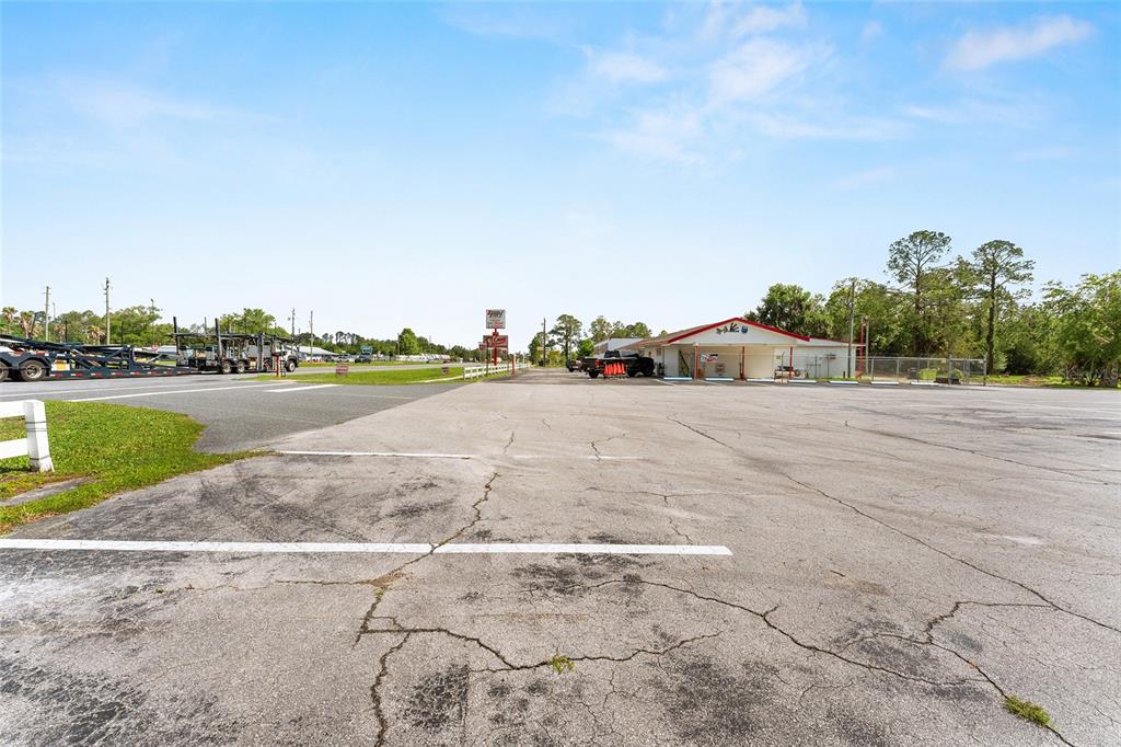 A large, cracked asphalt parking lot sits in front of a single-story commercial building — 17313 NE US HWY 301, WALDO, FL