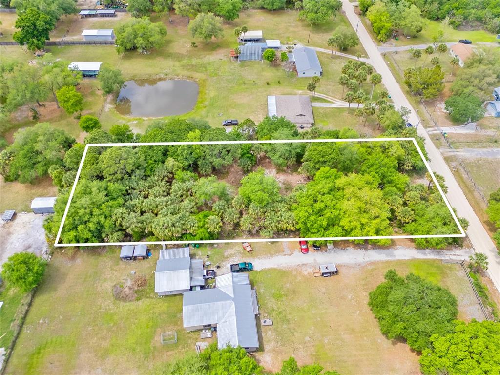 An aerial view shows a rectangular, tree-covered lot outlined in white next to a road — 5175 VACARO AVENUE, COCOA, FL