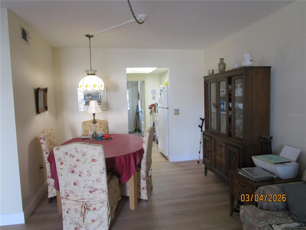 A dining area features a round table with floral chairs, a hutch, and light flooring — 5920 18TH STREET N UNIT 8, ST PETERSBURG, FL