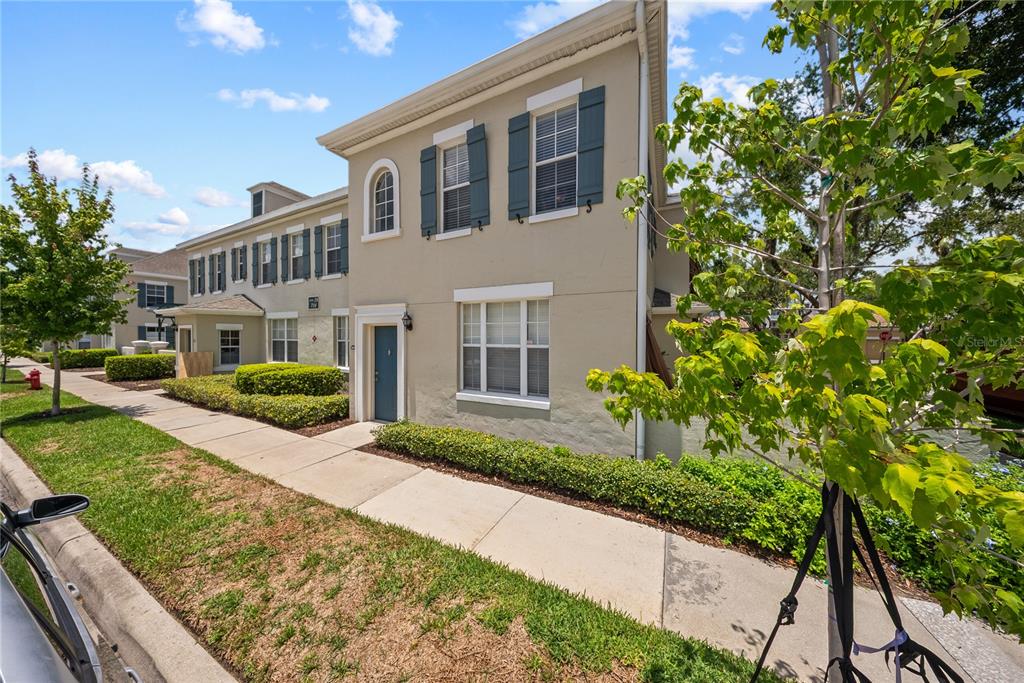 A two-story tan townhome with dark shutters and a sidewalk in front — 714 SIENA PALM DRIVE UNIT 201, CELEBRATION, FL