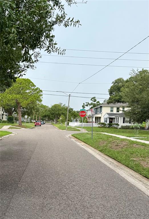 A residential street scene features a stop sign at an intersection near a white house — 766 51ST AVENUE N, ST PETERSBURG, FL