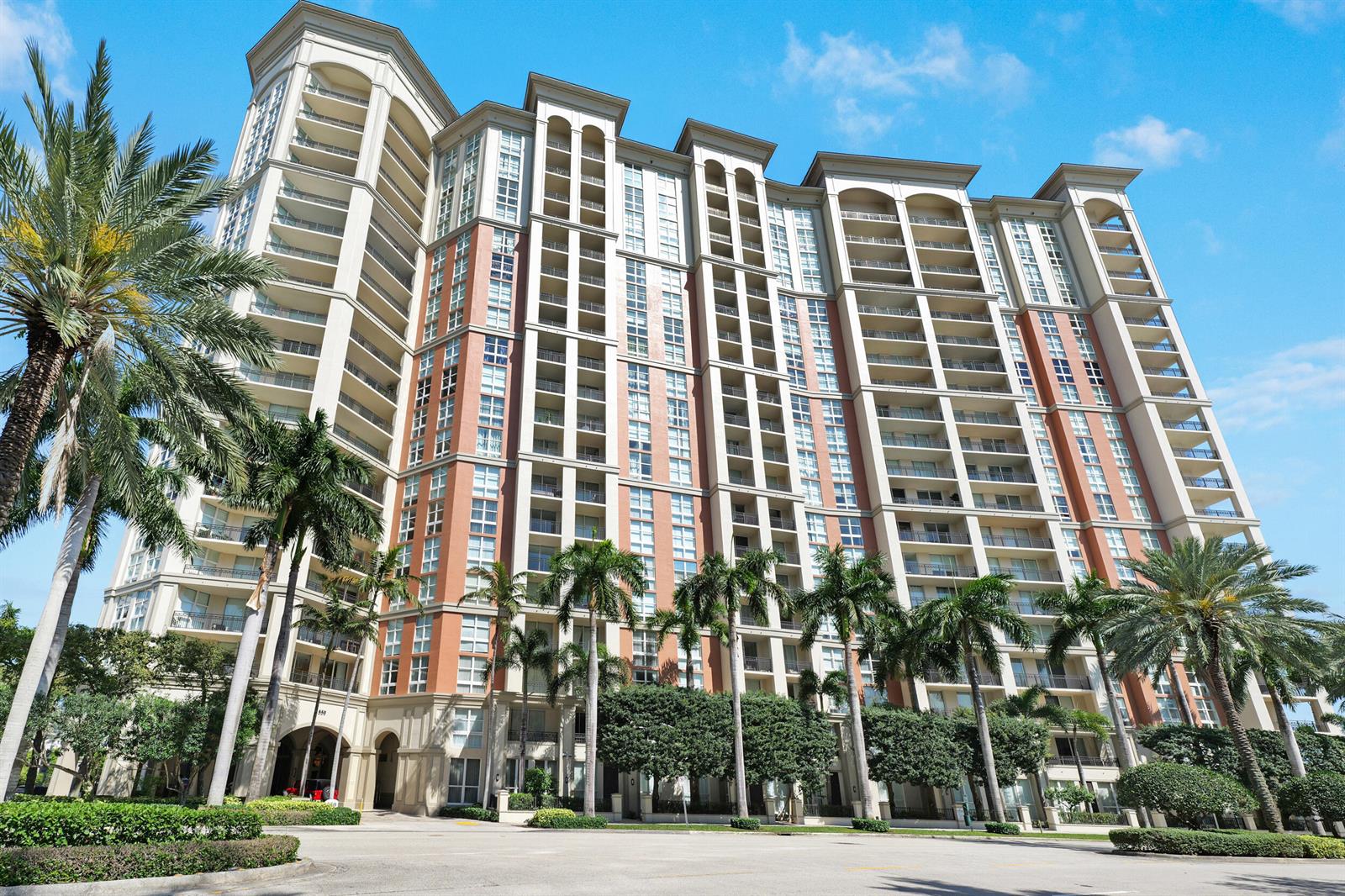 A low-angle exterior view of a multi-story residential building with balconies and surrounding palm trees — 550 Okeechobee Boulevard # 622, West Palm Beach FL 33401, WEST PALM BEACH, FL