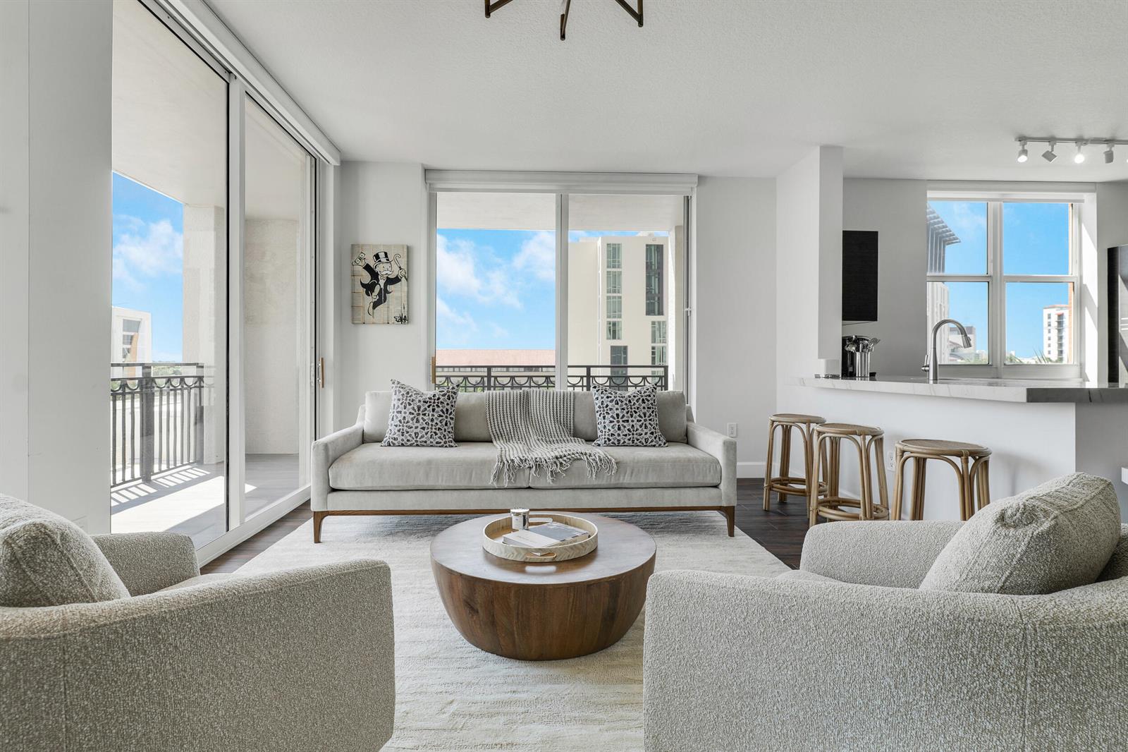A living room with a sofa, two armchairs, a round coffee table, and a kitchen bar — 550 Okeechobee Boulevard # 622, West Palm Beach FL 33401, WEST PALM BEACH, FL