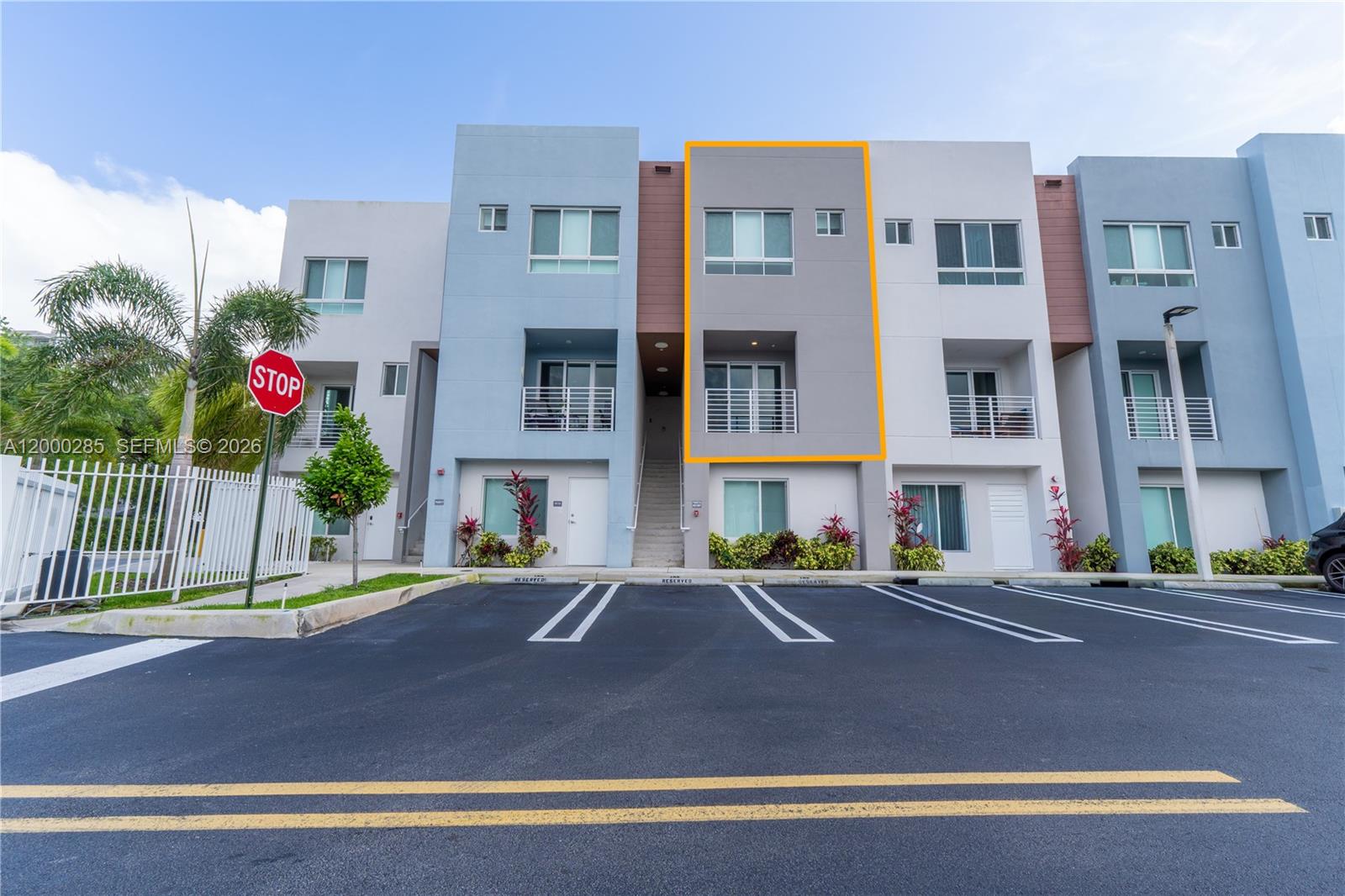 A three-story townhouse exterior with a gray facade and a balcony is shown — 2505 NE 193rd St # 4215, Miami FL 33180, MIAMI, FL