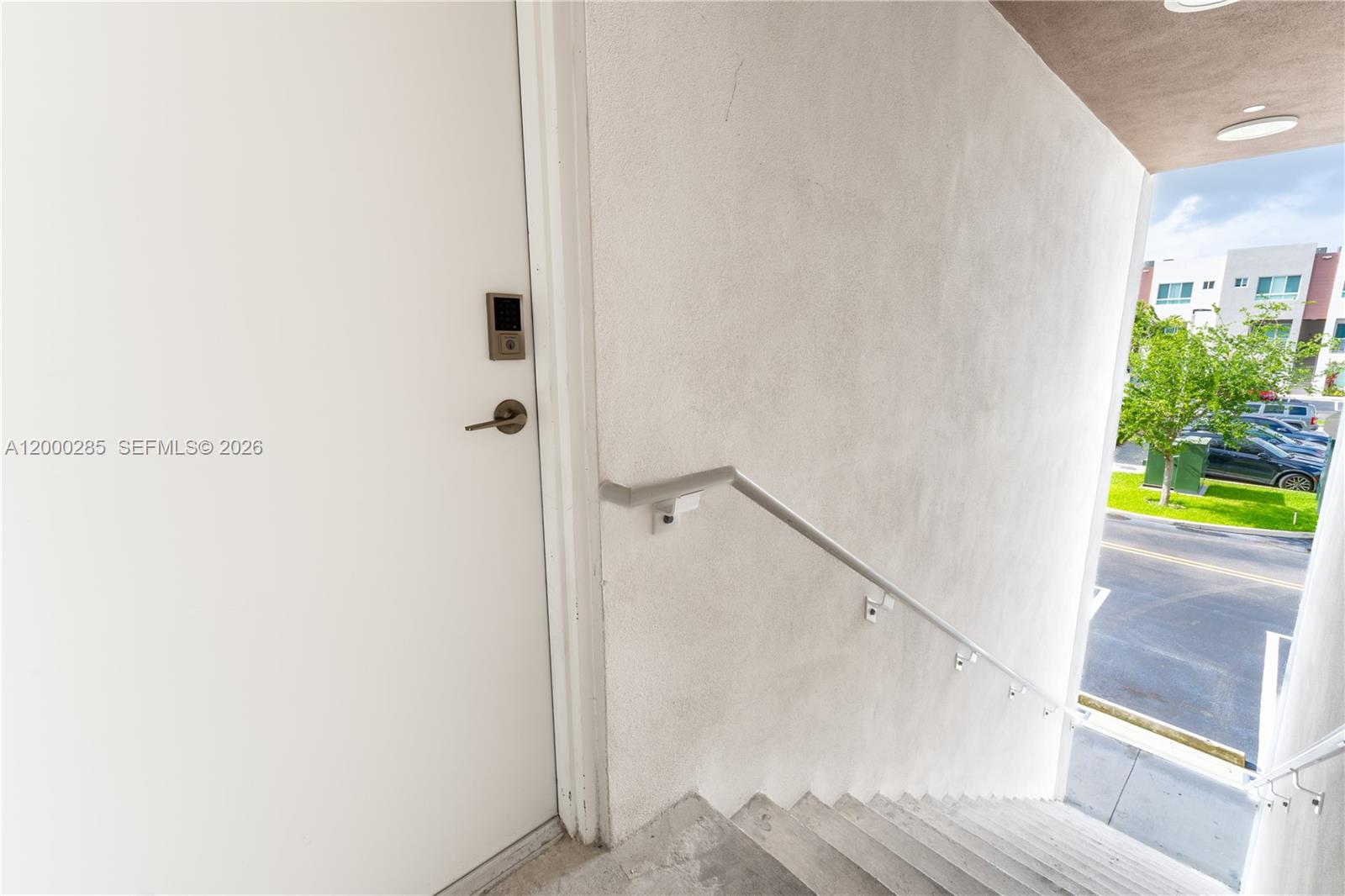A white door with a digital lock sits at the top of an outdoor staircase — 2505 NE 193rd St # 4215, Miami FL 33180, MIAMI, FL