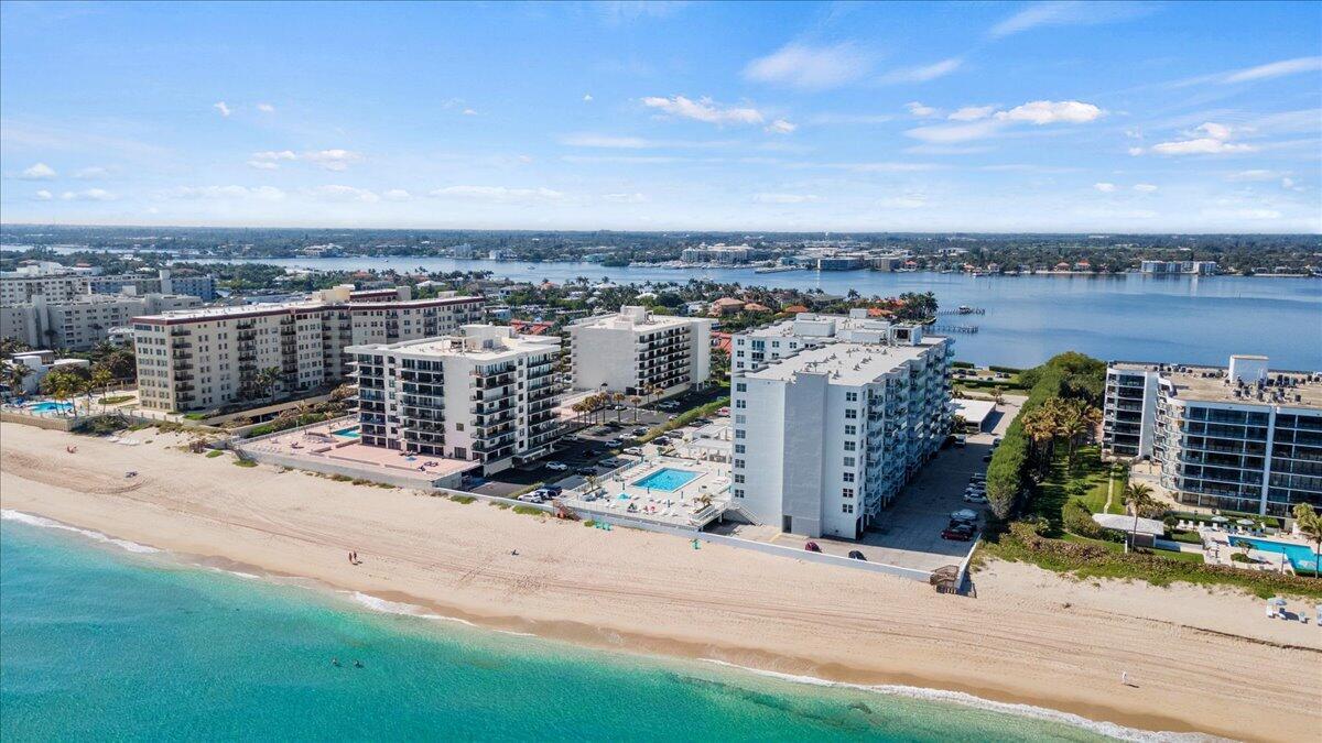 An aerial view of beachfront apartment buildings with swimming pools along a sandy coastline — 3450 S Ocean Boulevard # 812, Palm Beach FL 33480, PALM BEACH, FL