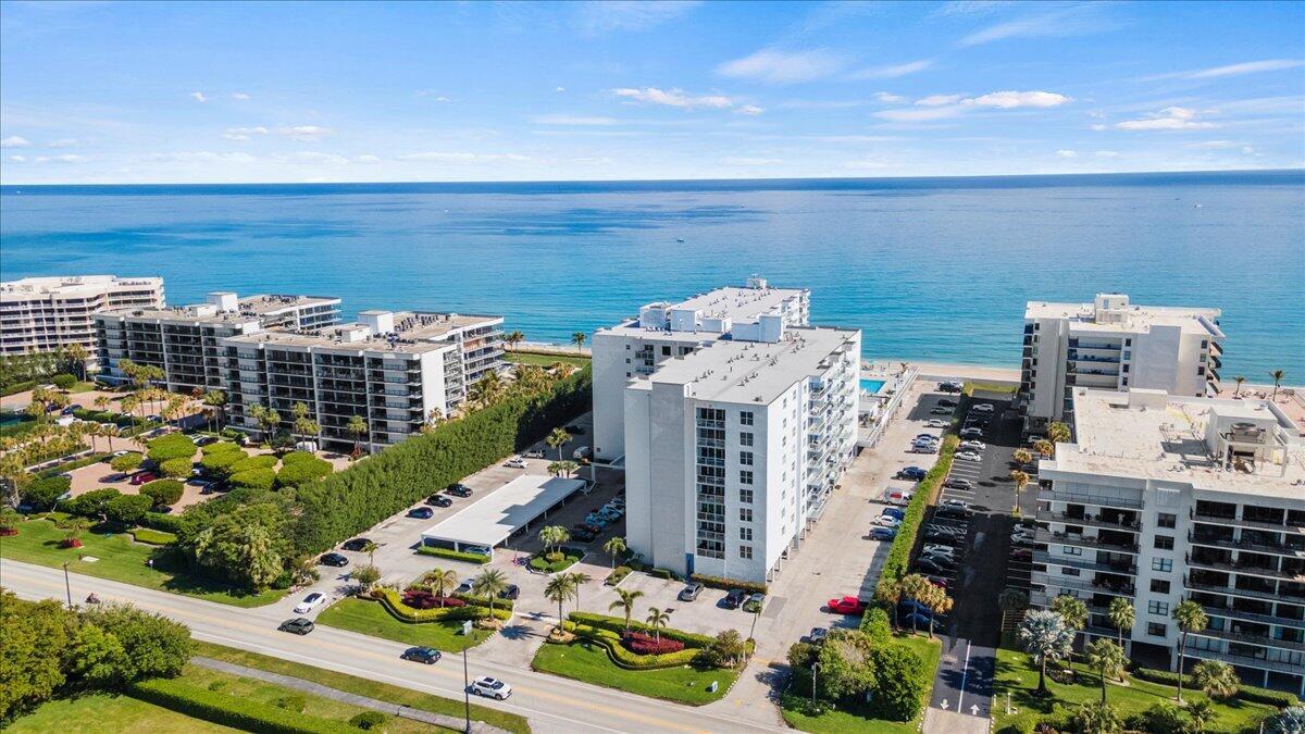 An aerial view shows several white apartment buildings situated along a sandy beach and ocean — 3450 S Ocean Boulevard # 812, Palm Beach FL 33480, PALM BEACH, FL