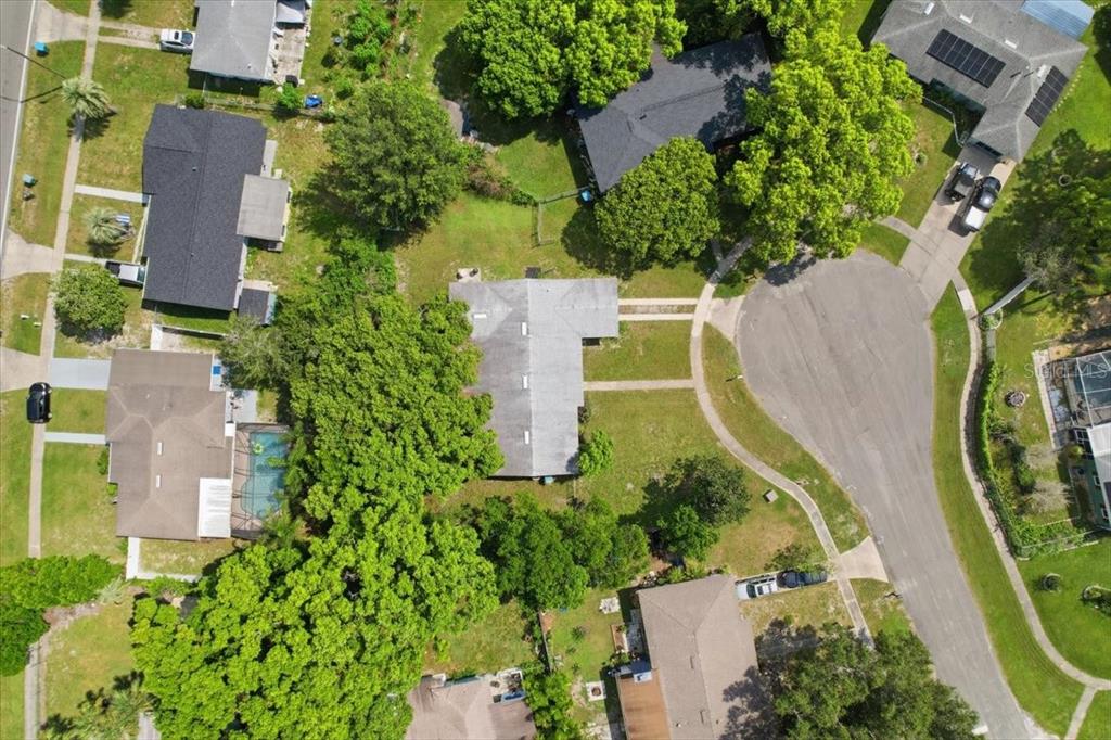 An aerial view shows a residential neighborhood with houses, driveways, and mature trees — 1220 SIENNA COURT, DELTONA, FL