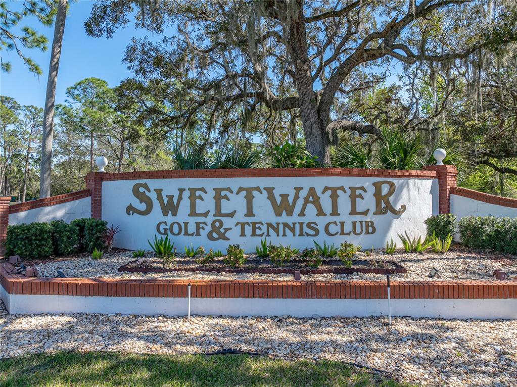 A brick and stucco monument sign displays the name Sweetwater Golf & Tennis Club — 102 NEWCASTLE BOULEVARD, HAINES CITY, FL