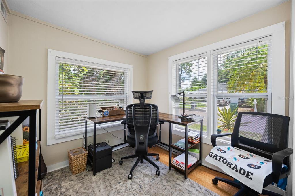 A home office features an L-shaped desk, two mesh chairs, and windows with white blinds — 907 18TH AVENUE W, PALMETTO, FL
