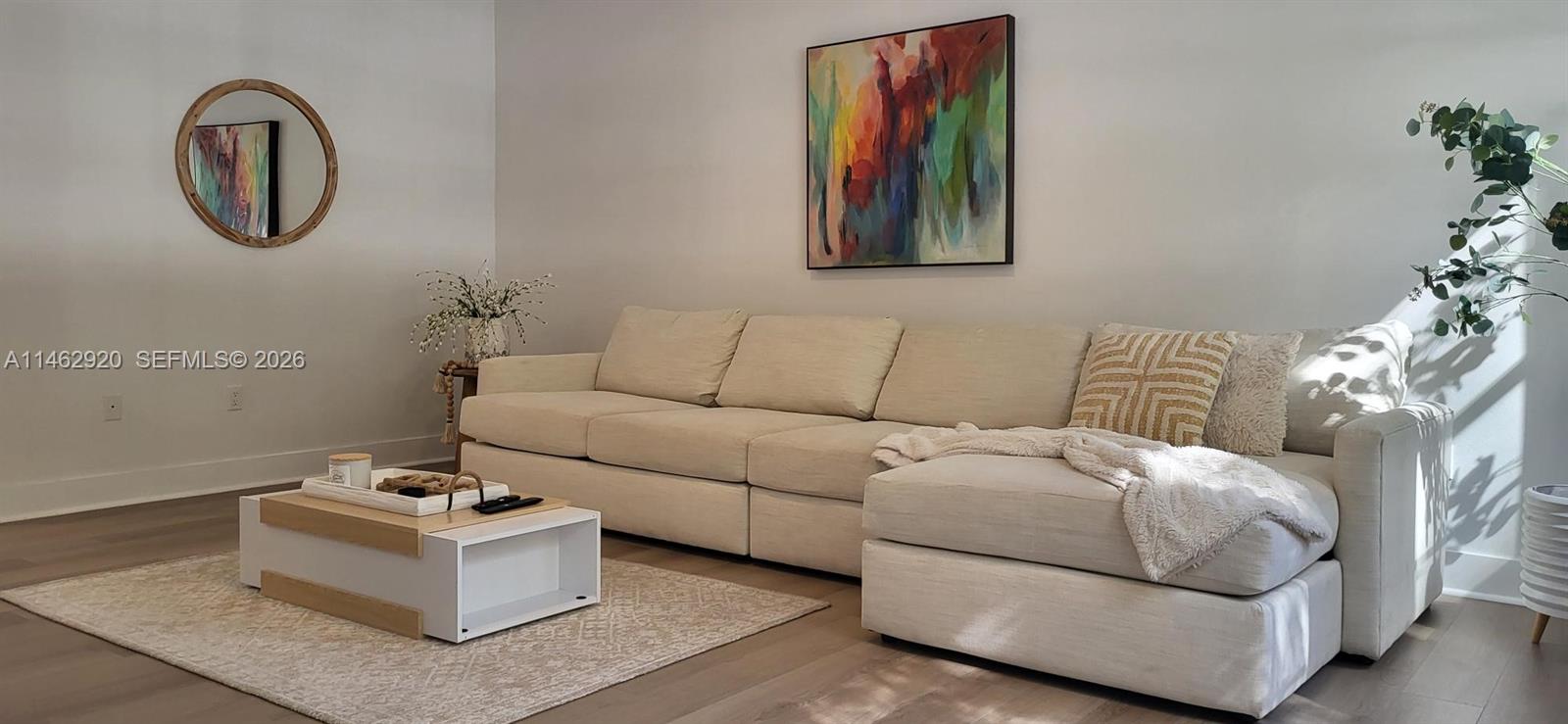A living room features a beige sectional sofa, a white coffee table, and abstract wall art — 2069 S Ocean Dr, Hallandale Beach FL 33009, HALLANDALE BEACH, FL