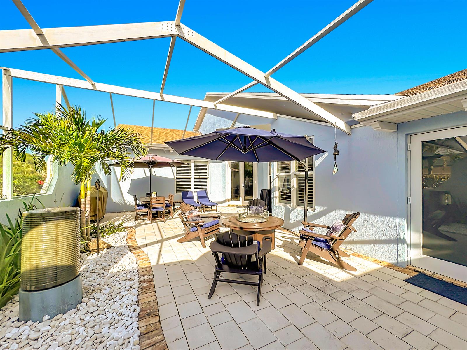 A screened-in patio features a paved floor, a fire pit table, and outdoor seating — 208 River Walk, Fort Pierce FL 34949, FORT PIERCE, FL