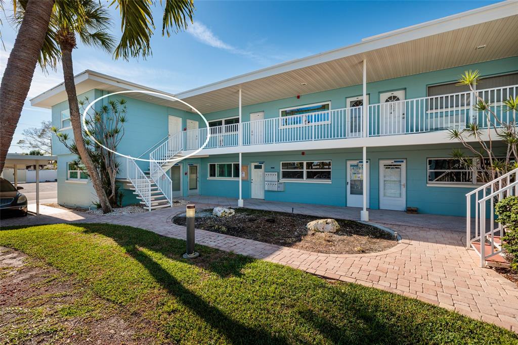 A two-story teal apartment building with an exterior staircase and a white metal railing — 6000 2ND STREET E UNIT 6, ST PETE BEACH, FL
