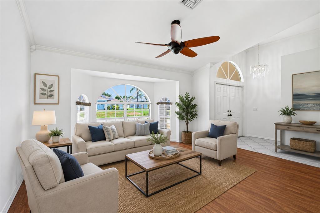 A living room features a beige sofa, two armchairs, a coffee table, and large windows — 4042 DULUTH TERRACE, NORTH PORT, FL