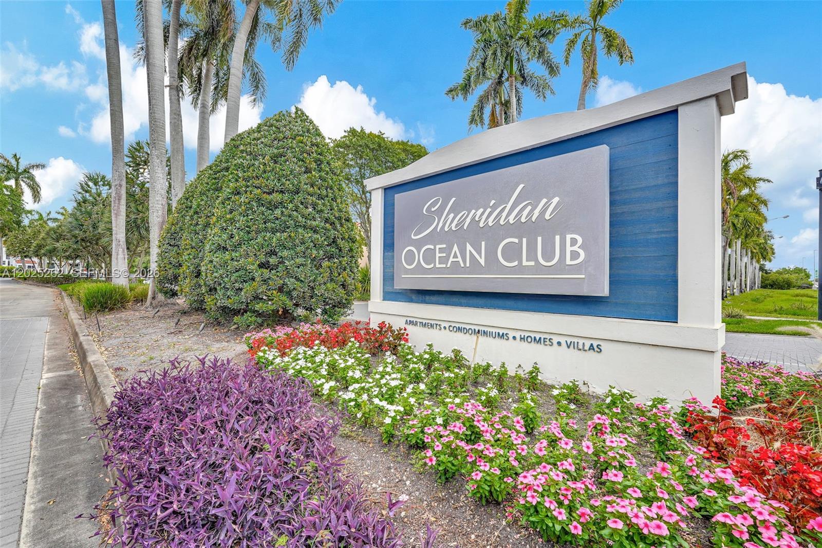 A sign for the Sheridan Ocean Club stands in front of landscaping and palm trees — DANIA BEACH, FL