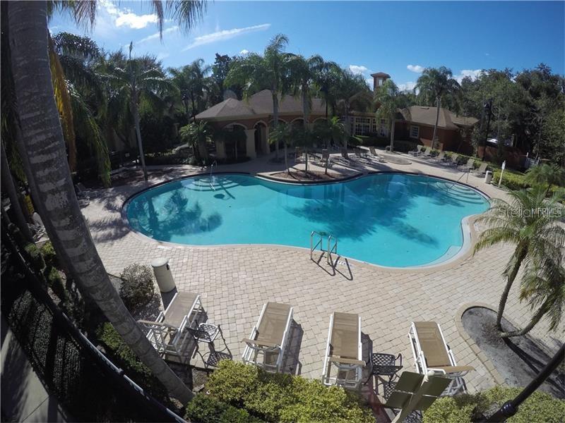 An elevated view of a swimming pool surrounded by lounge chairs and palm trees — 830 GRAND REGENCY POINTE UNIT 103, ALTAMONTE SPRINGS, FL