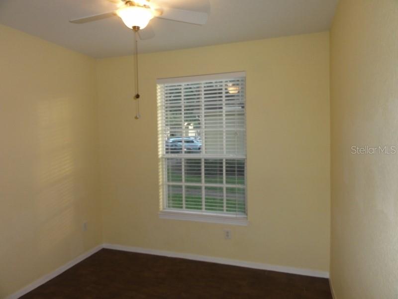 A bedroom with yellow walls, a ceiling fan, and a window with white blinds — 830 GRAND REGENCY POINTE UNIT 103, ALTAMONTE SPRINGS, FL