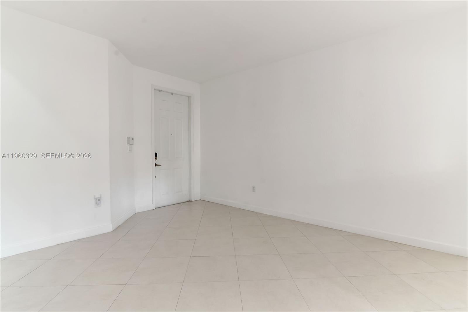 An empty room features white walls, a white door, and light-colored tile flooring — 11321 NW 84th St, Doral FL 33178, DORAL, FL
