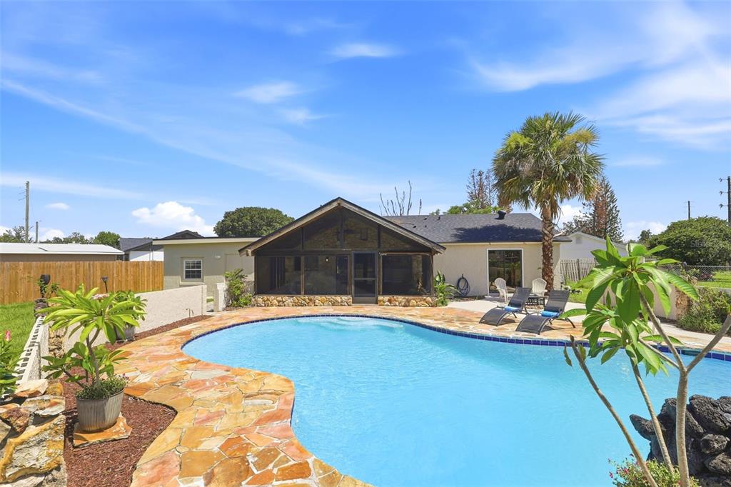 A backyard features a swimming pool with stone decking and a screened-in patio area — 4072 VANET COURT, ORLANDO, FL