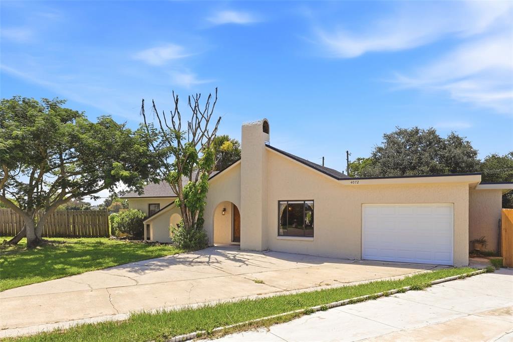 A single-story house with a beige stucco exterior, a chimney, and an attached garage — 4072 VANET COURT, ORLANDO, FL