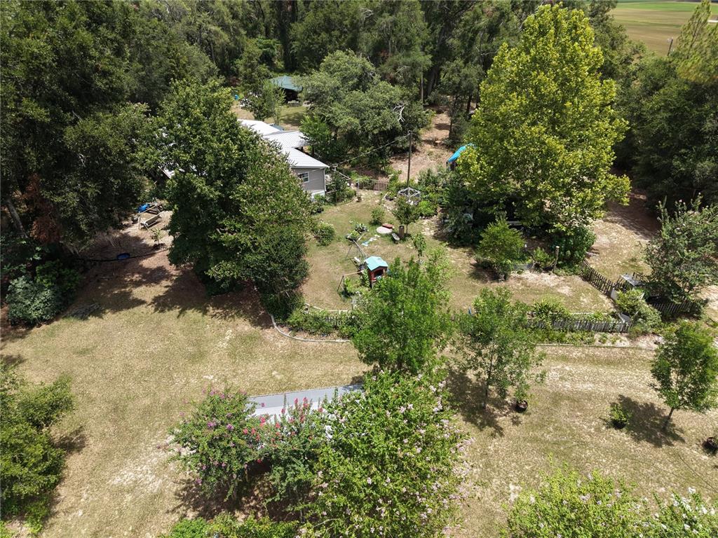 An aerial view shows a house surrounded by trees, a yard, and garden areas — 6482 SE 55TH STREET, TRENTON, FL