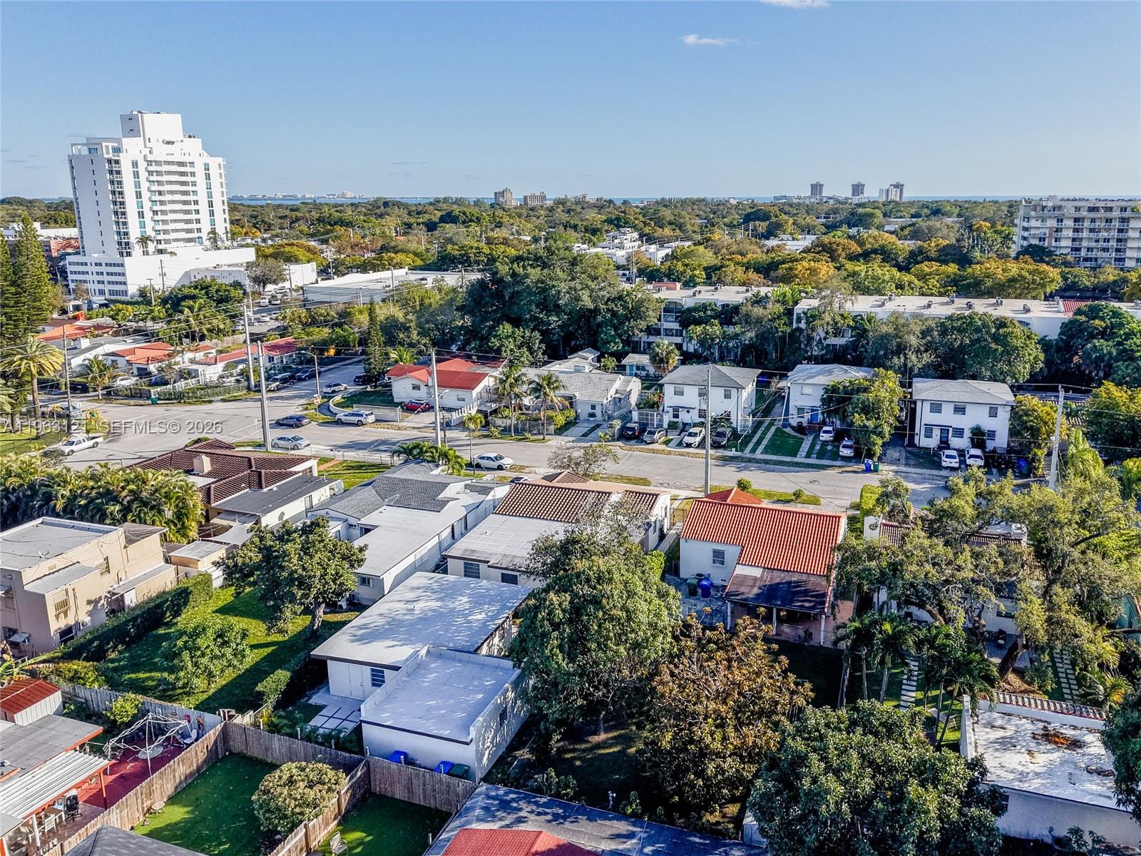 An aerial view shows a residential neighborhood with houses, trees, and a distant city skyline — 1631 SW 21st St, Miami FL 33145, MIAMI, FL