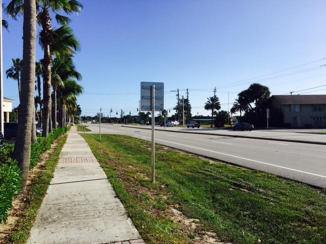 A sidewalk runs alongside a road lined with palm trees under a clear blue sky — 14050 Us Highway 1 # F, Juno Beach FL 33408, JUNO BEACH, FL