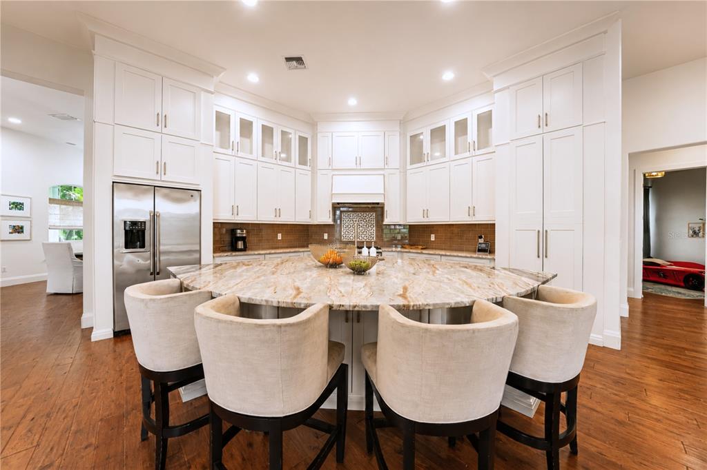A bright foyer features a striped rug, a console table with lamps, and double glass doors — 3450 FOXMEADOW COURT, LONGWOOD, FL