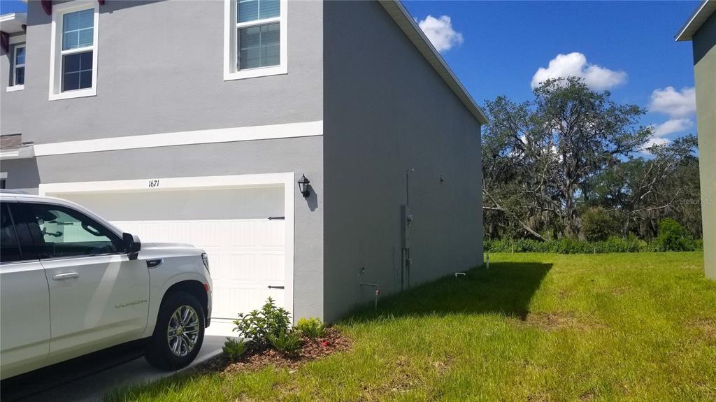 A white pickup truck is parked in front of a gray two-story house with a garage — 1671 ROSYDALE CIRCLE, DAVENPORT, FL