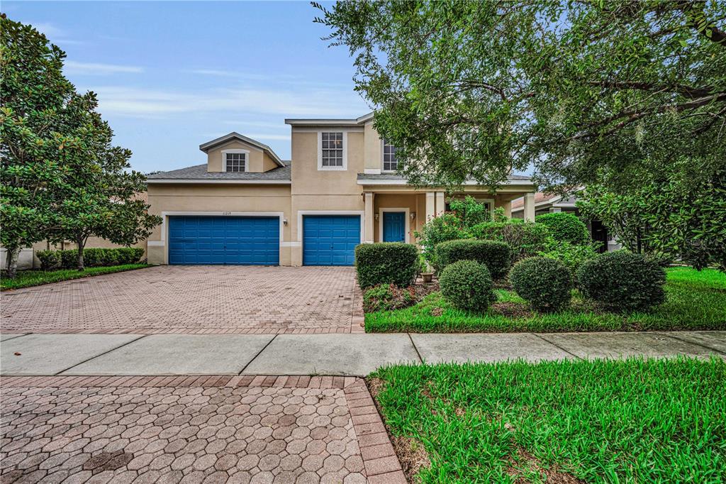 A two-story house with a blue three-car garage and a paved driveway — 11217 LAUREL BROOK COURT, RIVERVIEW, FL