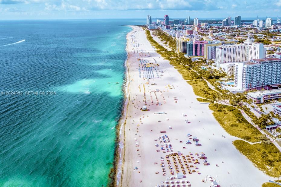 An aerial view of a sandy beach lined with high-rise buildings along the ocean — 934 Meridian Ave # 7, Miami Beach FL 33139, MIAMI BEACH, FL