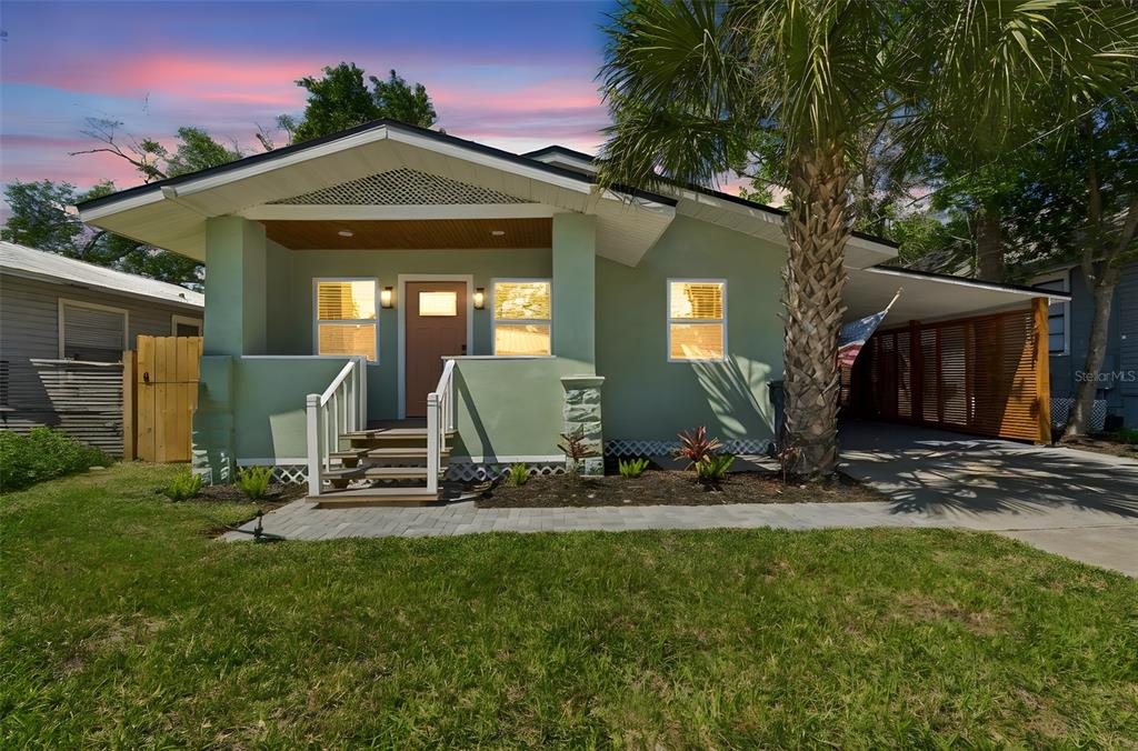 A light green bungalow with a front porch, a palm tree, and a side carport — 106 E FERN STREET, TAMPA, FL