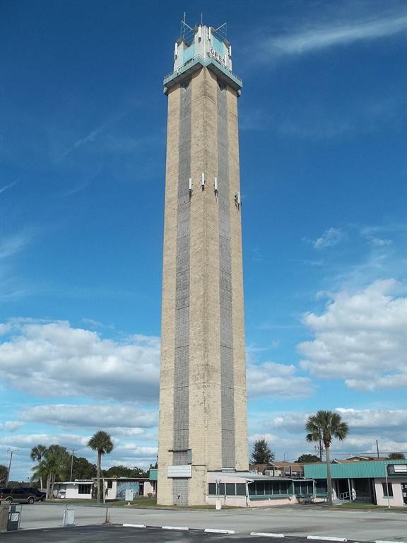 A tall, rectangular concrete tower stands against a blue sky in a parking lot — 5906 Quince Road, Sebring FL 33875, SEBRING, FL