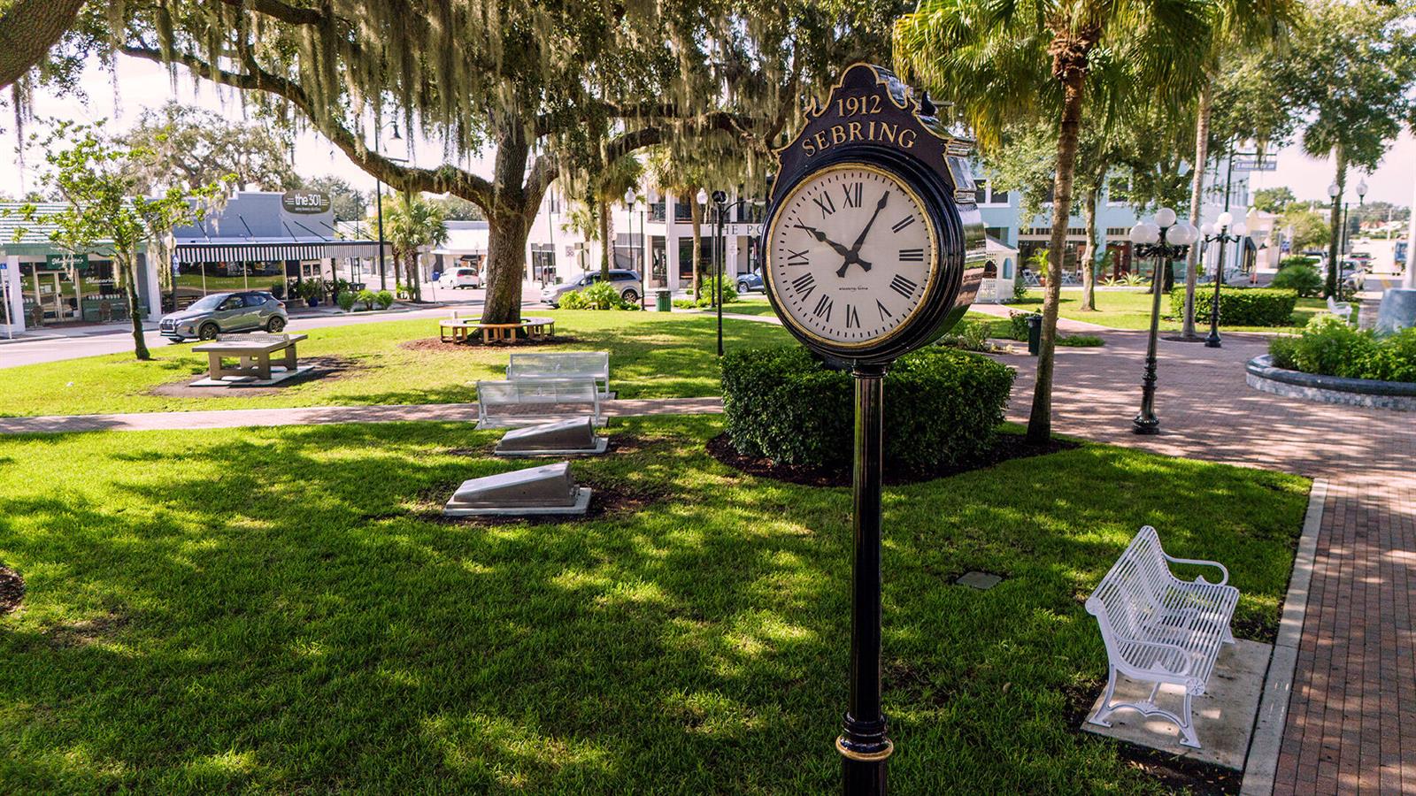 A public park features a prominent 1912 Sebring clock, green lawn, and white benches — 5906 Quince Road, Sebring FL 33875, SEBRING, FL