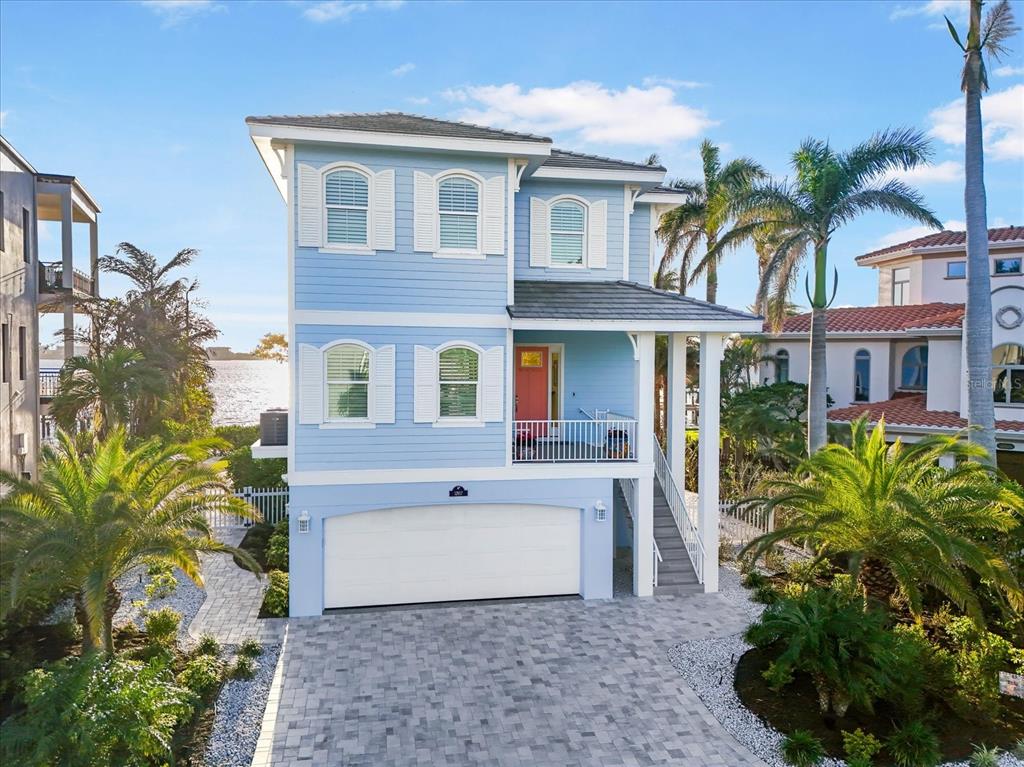 A light blue two-story house with a white garage and a front porch — 12917 42ND TERRACE W, CORTEZ, FL