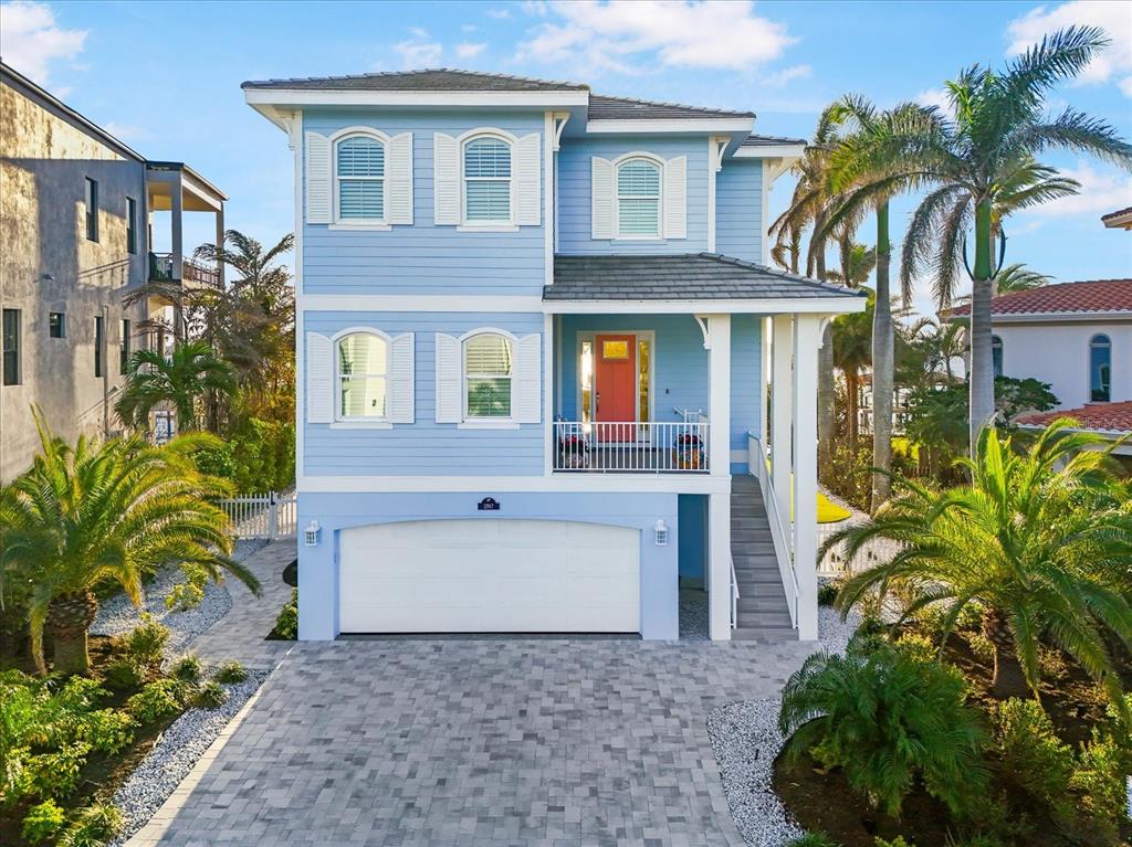 A light blue two-story house with a white garage and a front staircase — 12917 42ND TERRACE W, CORTEZ, FL