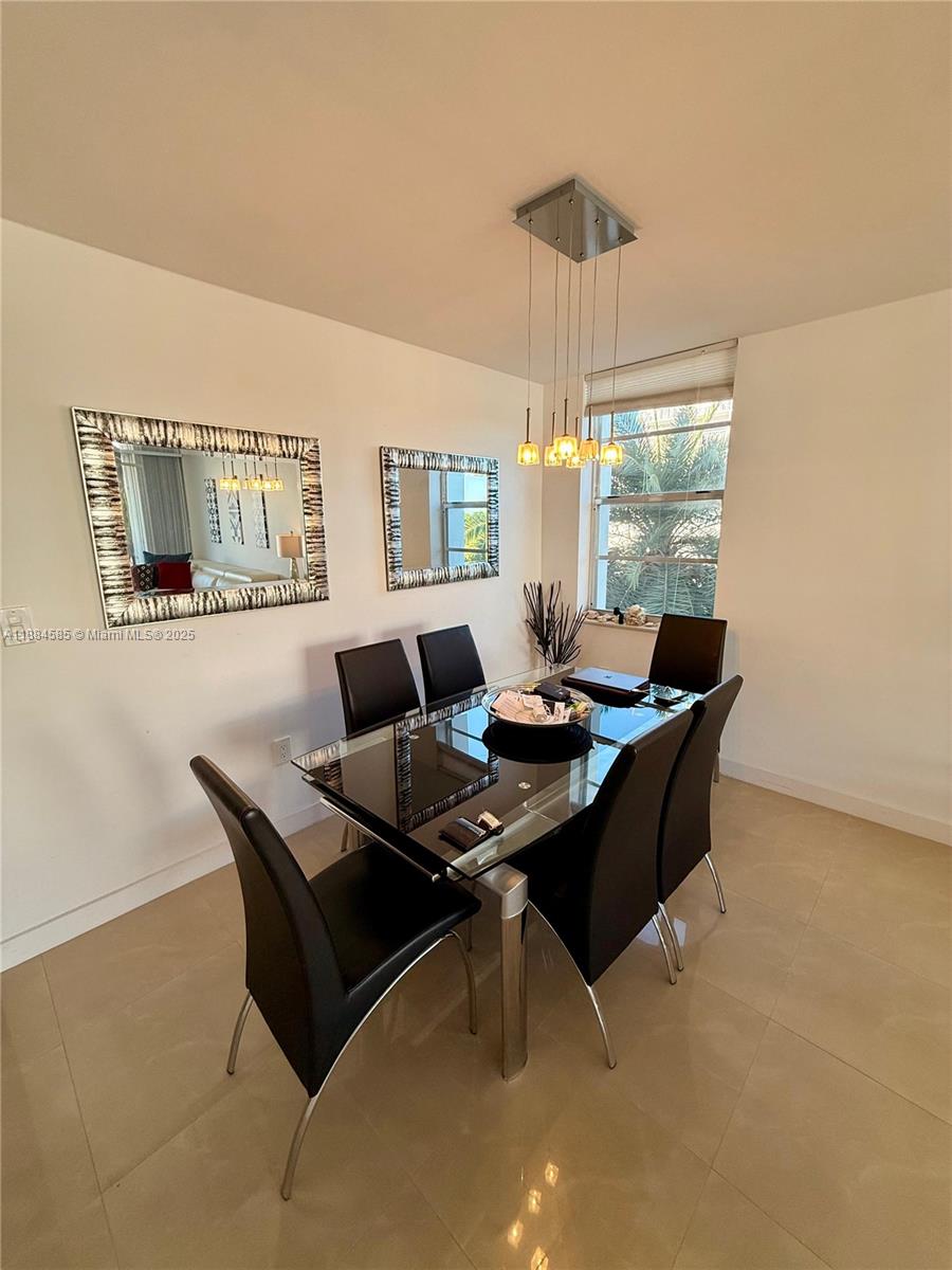 A dining room features a glass-topped table, six black chairs, and two wall mirrors — 4142 N Jefferson Ave # 4D, Miami Beach FL 33140, MIAMI BEACH, FL