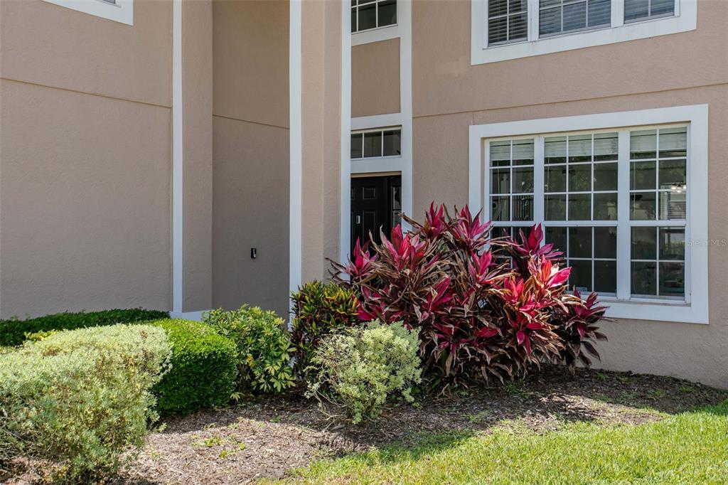 The exterior of a two-story home features tan stucco walls, white trim, and landscaping — 3010 42ND AVENUE E, BRADENTON, FL