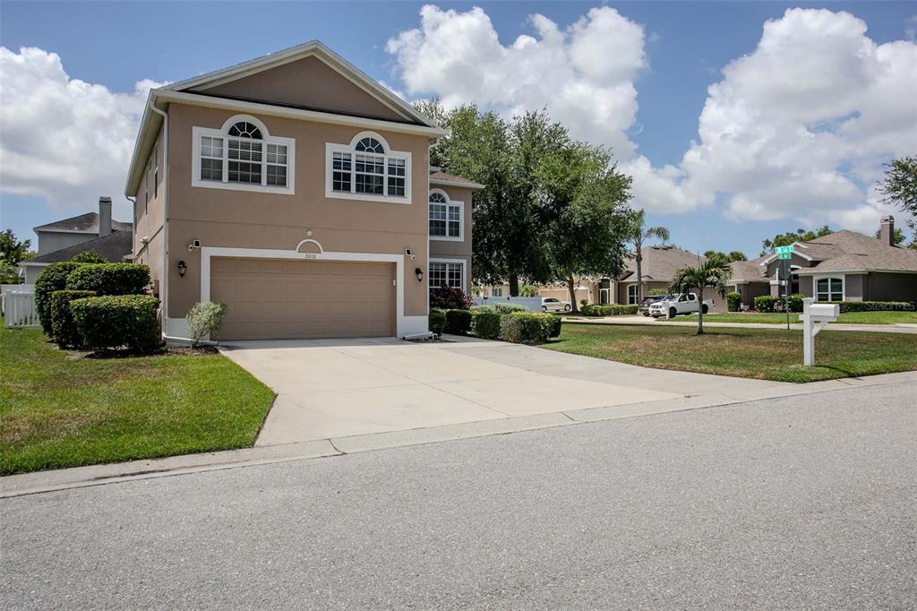A two-story tan house with a two-car garage and a concrete driveway — 3010 42ND AVENUE E, BRADENTON, FL
