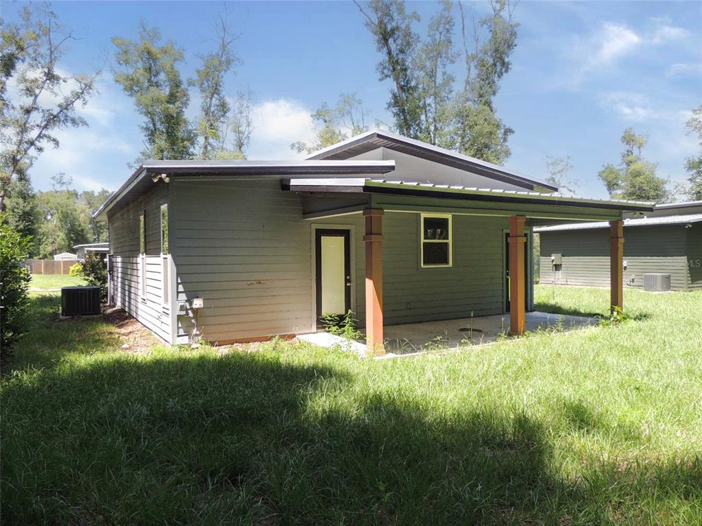 A gray house with a covered patio, wooden support posts, and a metal roof — 7439 SE 78TH PLACE, TRENTON, FL