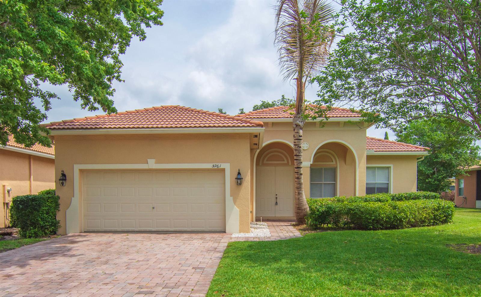 A single-story stucco house with a tile roof, a two-car garage, and a palm tree — 5961 Spanish River Road, Fort Pierce FL 34951, FORT PIERCE, FL