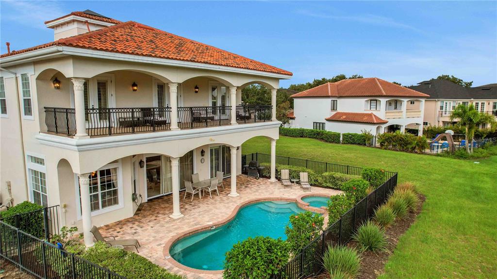 A two-story house with a tiled roof, a balcony, and a backyard swimming pool — 7438 GATHERING COURT, REUNION, FL